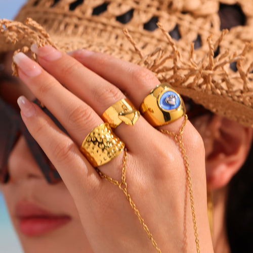 Close face portrait hand wearing gold hammered wide open ring