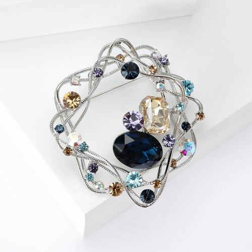 A looping wire nest around a large faceted center stone shown in a styled display.