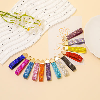 Thirteen rhinestone leather strap findings fanned in mixed colors