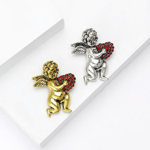 Gold and silver cherub angel heart brooches pair on white display