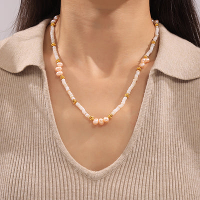 Pearl and shell disc beaded necklace worn on collarbone