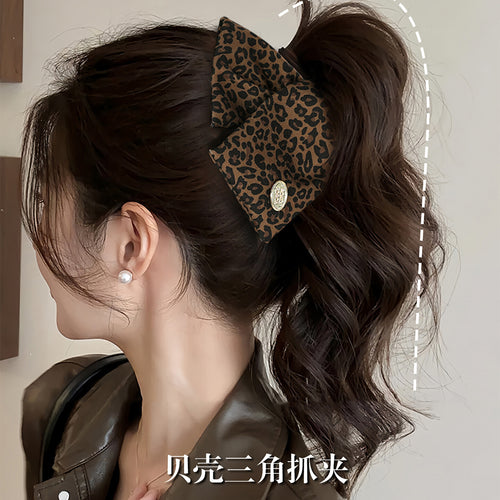 Deep coffee leopard triangle claw clip worn in high ponytail