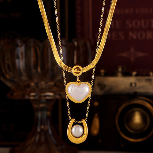 Gold heart pearl and horseshoe pearl necklaces layered together