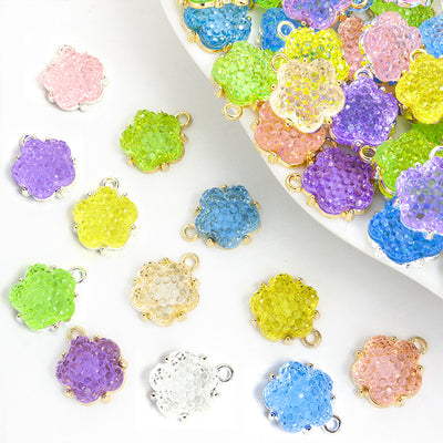 Assorted flower cluster charms arranged beside a mixed pile
