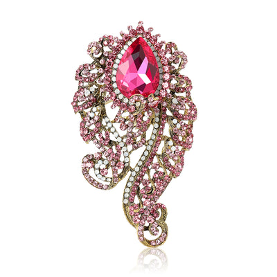 Front product view of the large faceted teardrop framed by sweeping crystal-set filigree brooch