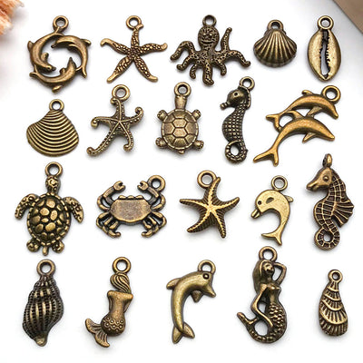 Gold-tone starfish and shell charms arranged on a light background