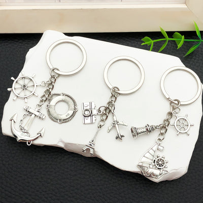 Overview showing the available color and design variations of the antique silver nautical anchor and sailboat keychain