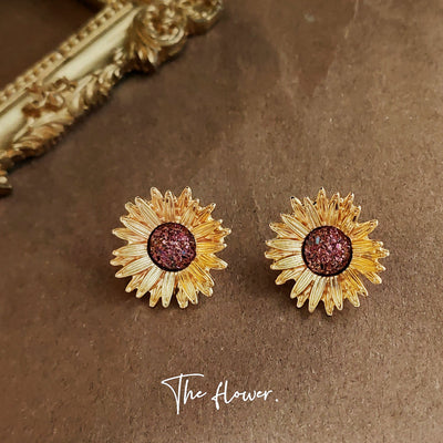 Gold-tone sunflower burgundy-glitter center studs in the first product display.