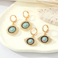 Gold Tone Crystal Turquoise Sun and Evil Eye Huggie Earrings view 1