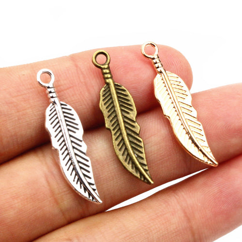 Slender feather charms showing assorted shapes and finishes