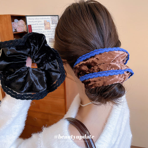 Black velvet scrunchie held and coffee blue-edge scrunchie on bun