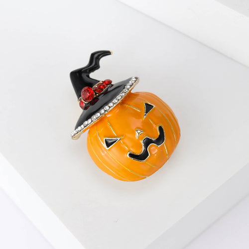 Angled display of the pumpkin witch hat brooch on a white surface