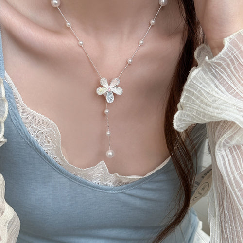 Styled view of 银色星花珍珠Y字项链 showing white pearls and small star-shaped flowers