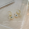 Gold Tone Blue Center Disc And Clear Flower Charm Huggie Earrings view 4