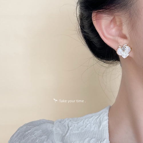 Model wearing pink white enamel flower stud on ear