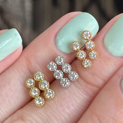 Gold rose and silver six-stone CZ flower studs on mint nails