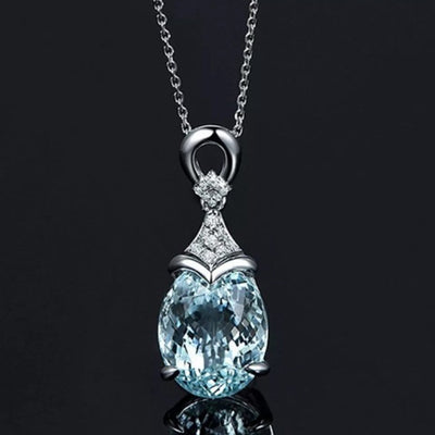 Sea blue oval CZ pendant on silver chain against dark background