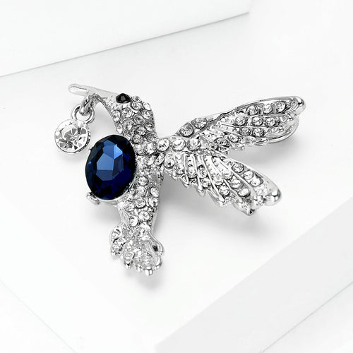 Hummingbird pin angled on white blocks showing wing pave crystals