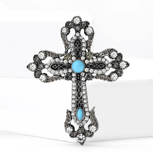 Front view of antique tone cross brooch with turquoise blue cabochons