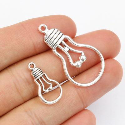 Assorted silver-tone light bulb outline charms in two sizes arranged together in the main product view