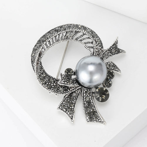 Grey pearl rhinestone bow brooch angled close-up