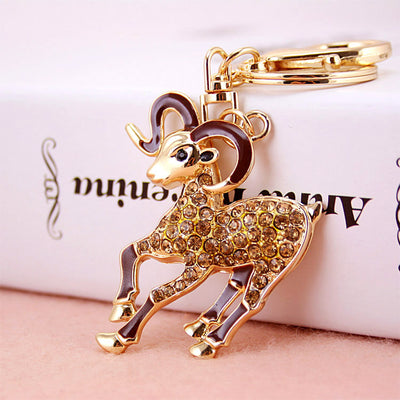 Gold-tone ram keychain with brown enamel accents, warm-toned stones, and a split ring.