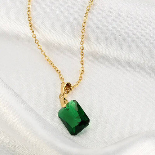 Green emerald-cut rectangle pendant close-up on white satin