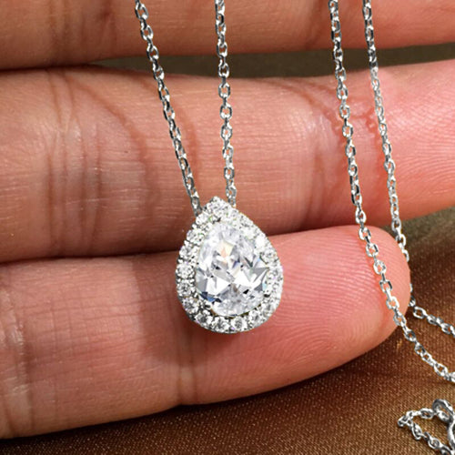 Silver-tone teardrop clear center pendant with clear halo on hand