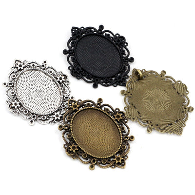 Overview of oval bezel trays surrounded by ornate openwork floral borders in four metallic finishes arranged on a light 
