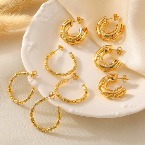 Assorted gold C-shape hoops on white plate hollow and bamboo