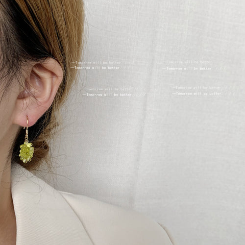 Gold-tone yellow-green grape-cluster hooks shown worn on an ear.