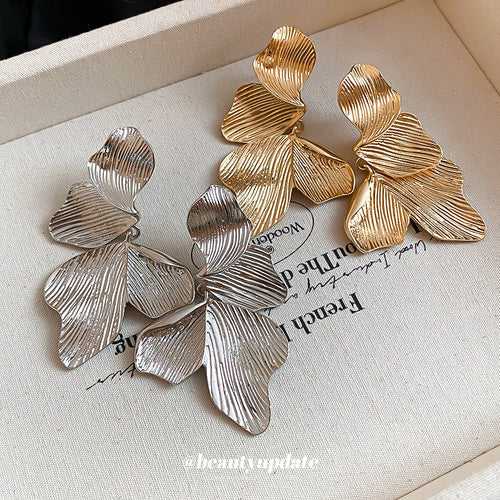 Stacked ribbed metal leaves forming broad botanical drops displayed in a close product arrangement.