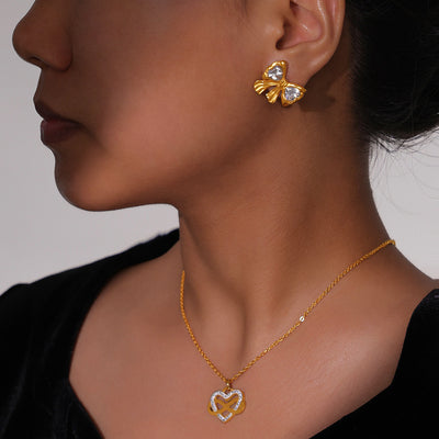 Gold bow crystal studs and heart infinity necklace worn together