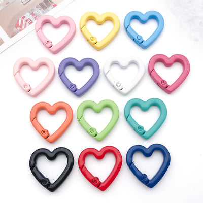 Colorful swivel clasp jewelry findings arranged on a light background