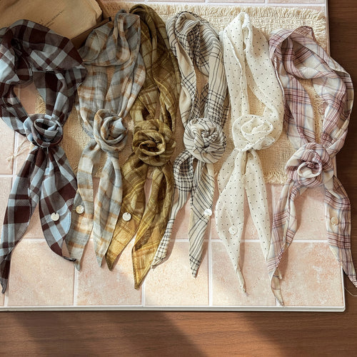 Styled view of narrow patterned scarf ties in seven neutral and blue designs