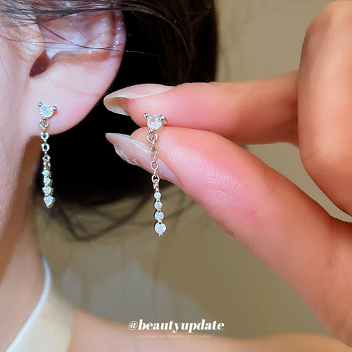 A styled close view of the linear crystal drop earrings.