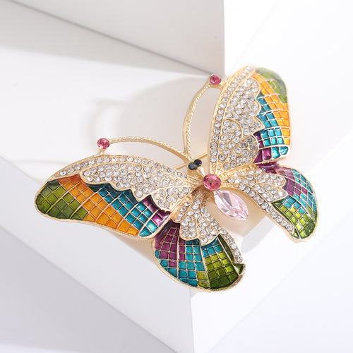 Angled view of grid enamel butterfly wings in green orange teal purple