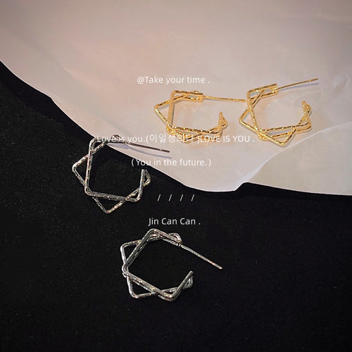 Gold and silver twisted square studs on black and white
