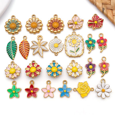 Colorful leaf and daisy charms arranged on a light background
