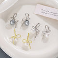 Gold Tone Bow White Pearl Look Ball Huggie Earrings view 1