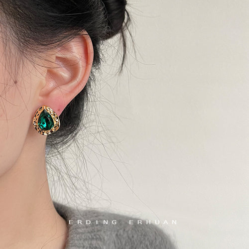 Emerald green teardrop stud worn on ear side profile