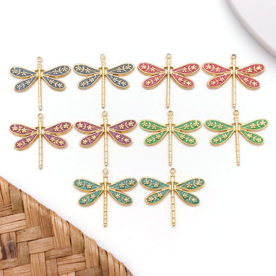 Colorful dragonfly charms arranged on a light background