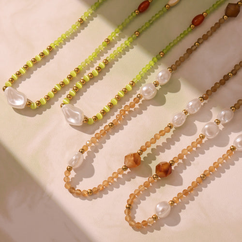 Matcha green and coffee brown pearl bead strands on fabric