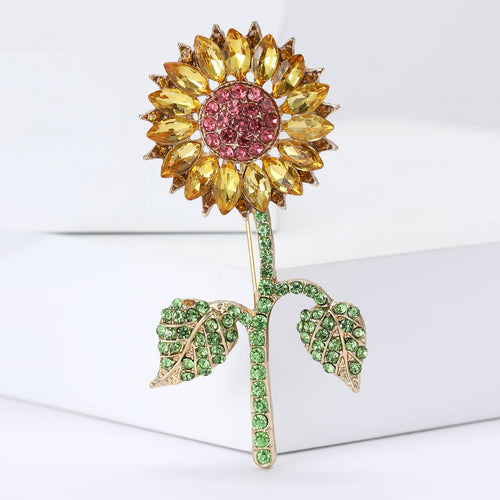 Angled display of the crystal sunflower brooch on a white surface