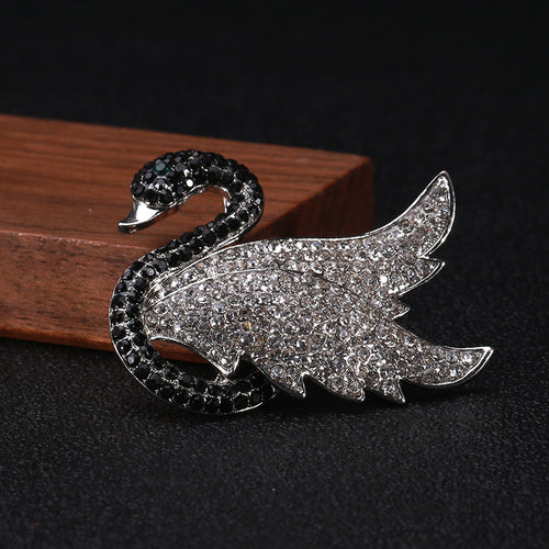 A black swan with a sweeping pavé crystal wing shown in a styled display.