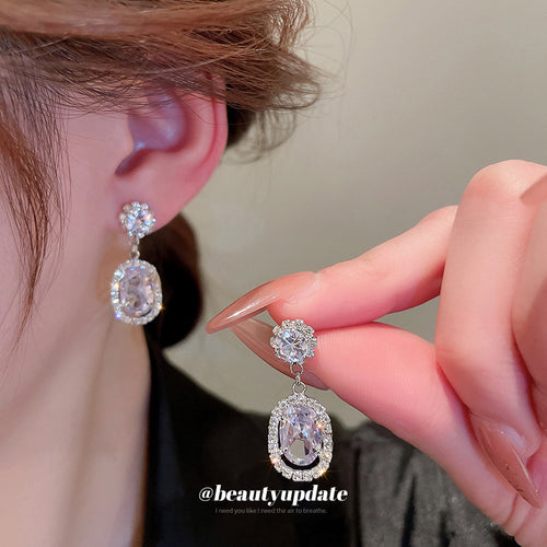 Alternate angle of silver tone clear crystal oval drop earrings in two designs