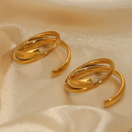 Two gold open double band crossover rings on satin fabric