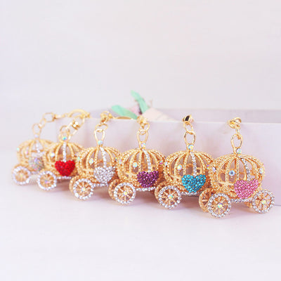 Six gold-tone heart carriage charms are arranged in a row in assorted colors.