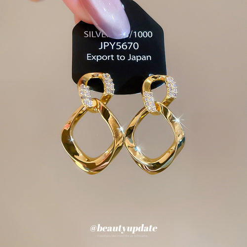 金色扭曲菱形垂坠耳环 in a displayed product view