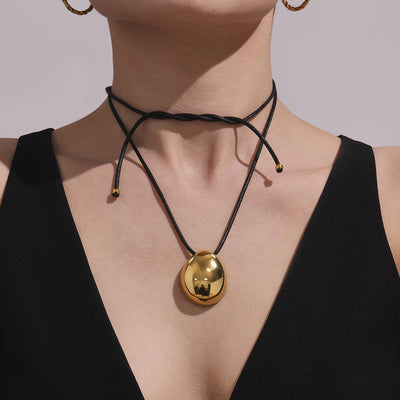 Neckline view of oval drop black cord necklaces in main image 1.